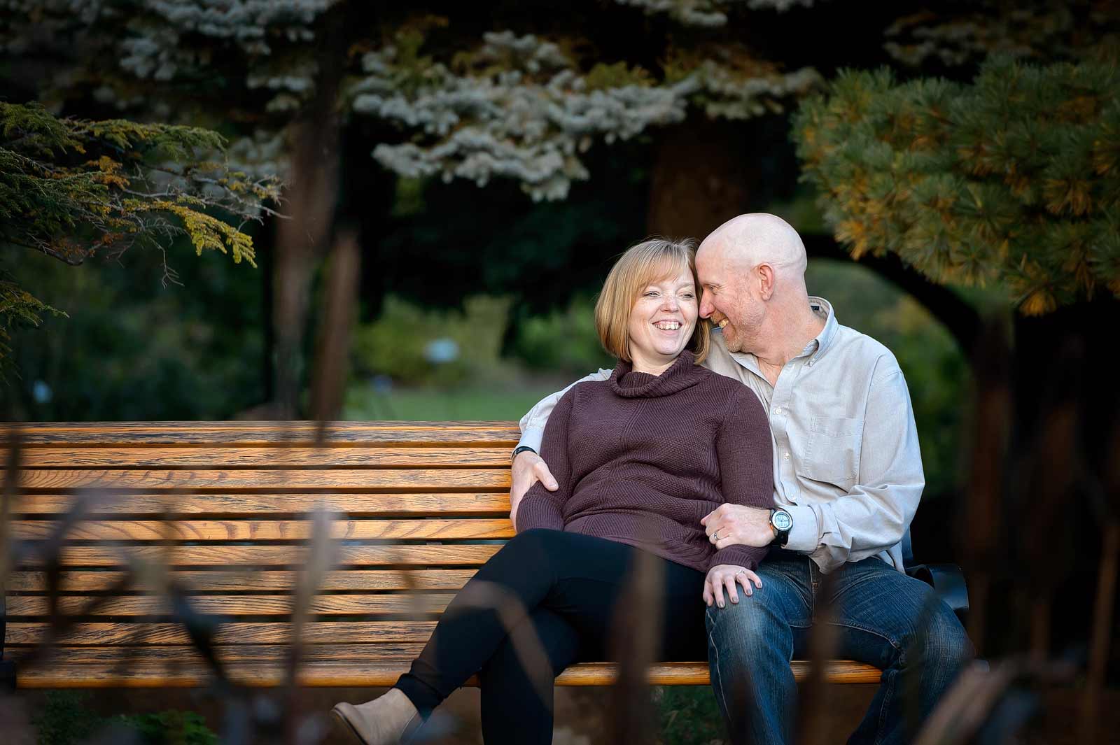 Couple laughing and sitting on a bench in the Ornamental Gardens